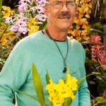 Bill Robson holding an Odontoglossum Yellow Parade orchid hybrid. Photo by Chuck Place.